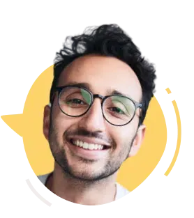 Ali Abdaal smiling in a blue shirt in a bright indoor setting